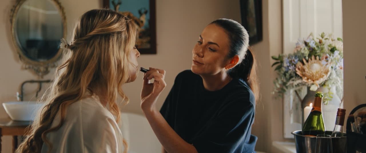 A makeup artist preparing a client for an event